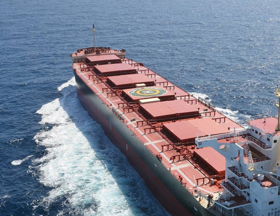 Panamax bulk carrier underway at sea, hatch covers closed over its cargo holds